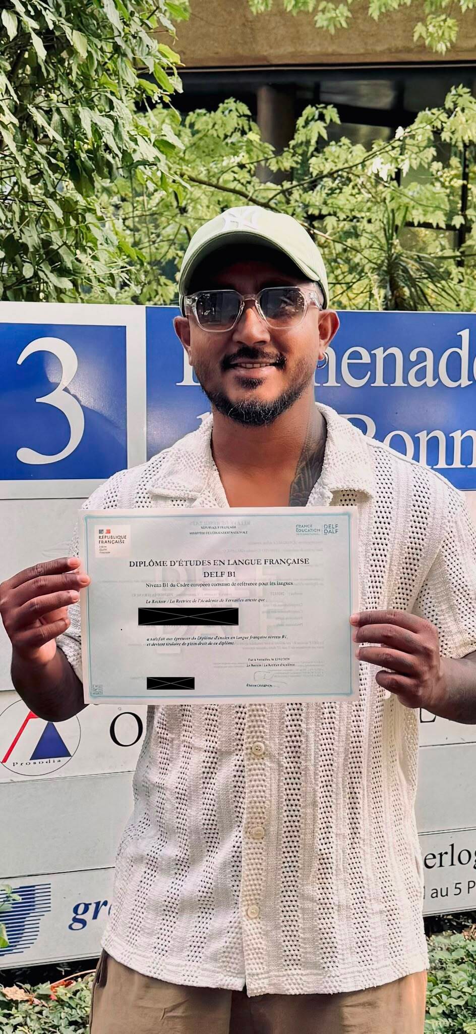 Awantha holding his DELF B1 diploma